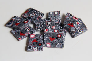 An array of polymer clay buttons in black, white, and red