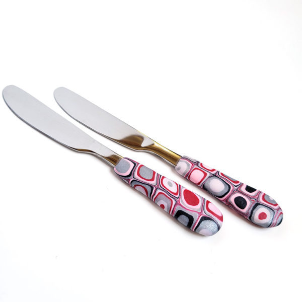 Pink, red, white, grey, and black spreaders butter knives